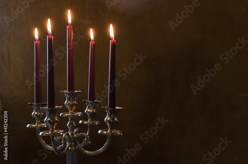 Photo: Five red candles lighted on painted room Five red candles lighted on painted room