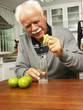 Abuelo exprimiendo limones en una cocina.