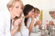 Three young women cleaning their teeth