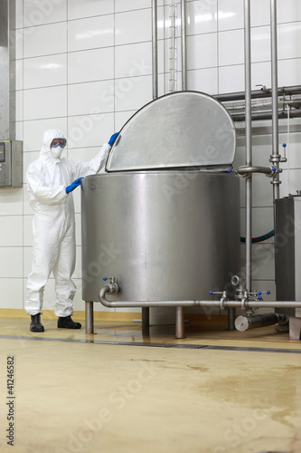 Photo: technician in uniform closing industrial process tank technician in uniform closing industrial process tank