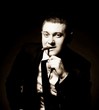 Photo: The man in style Chicago gangster with cigar on dark background The man in style Chicago gangster with cigar on dark background