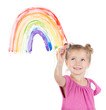 Little girl paints rainbow on window