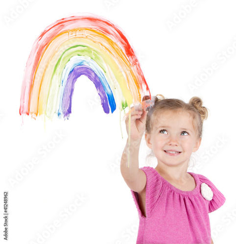 Photo: Little girl paints rainbow on window Little girl paints rainbow on window