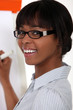 Woman with glasses writing on blackboard