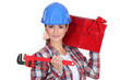 Woman carrying tool box on shoulder