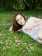 Beautiful woman lying on a garden of flowers and smiling