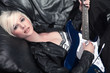hübsche blondýna frau auf der couch mit e gitarre rockt