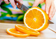 Woman's hands cutting orange