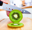 Woman's hands cutting kiwi