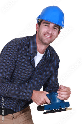 Photo: Workman with an electric sander Workman with an electric sander