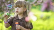 Laughing girl blowing bubbles