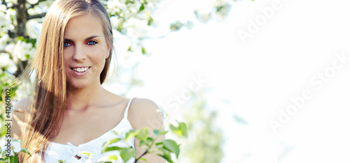 Foto: portrait of young lovely woman in spring flowers portrait of young lovely woman in spring flowers