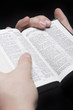 closeup of the hands of a man holding russian bible