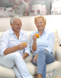 Pareja adulta bebiendo jugo de naranja en casa.