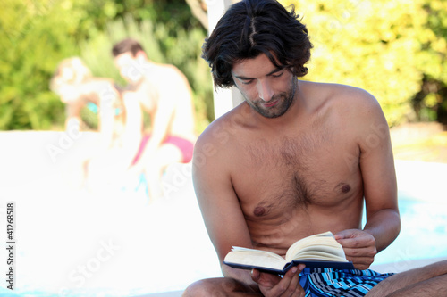 Photo: Man reading by the pool Man reading by the pool