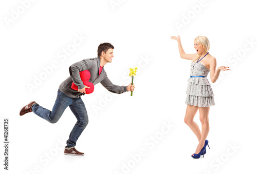 Photo: Boyfriend running with flowers and heart shape object towards hi Boyfriend running with flowers and heart shape object towards hi