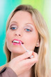 junge frau bekommt lippgloss aufgetragen
