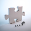 Tiny people looking at a puzzle piece
