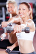 young woman doing dumbbell exercise in gym young woman doing dumbbell exercise in gym