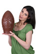 Young woman carrying big chocolate Easter egg