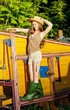 young woman standing by old threshing machine