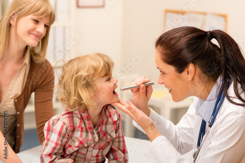 Photo: Pediatrician examine child throat look with light Pediatrician examine child throat look with light