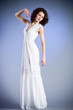Young woman in retro bridal dress on blue background.