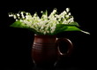 Bouquet lilies of the valley in a ceramic mug.