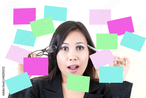 Photo: Business lady thinking with sticky note. Business lady thinking with sticky note.