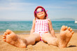 little girl lying on a sandy beach