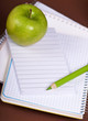 green apple and pencil on empty page of a notebook green apple and pencil on empty page of a notebook