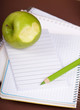 green apple and pencil on empty page of a notebook green apple and pencil on empty page of a notebook