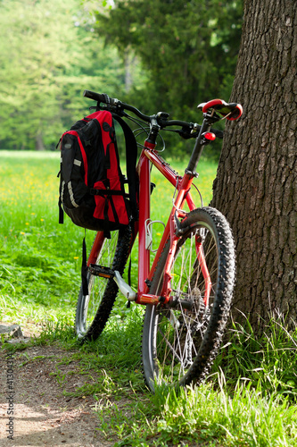 Photo: Bike and backpack among the green of nature in spring Bike and backpack among the green of nature in spring