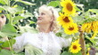 Beautiful middle-aged woman in sunflowers