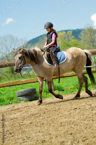Photo: Horse riding - lovely girl is riding a horse Horse riding - lovely girl is riding a horse