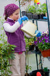 Gardening - lovely girl watering plants in green house Gardening - lovely girl watering plants in green house