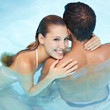 Frau umarmt Mann im Wasser