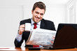 Man reading a newspaper in the office