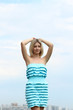 Young blond woman in sexy dress on background of the sky