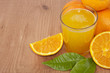 vaso con zumo de naranja, naranjas y hojas verdes vaso con zumo de naranja, naranjas y hojas verdes