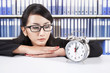 Businesswoman looking at alarm clock Businesswoman looking at alarm clock