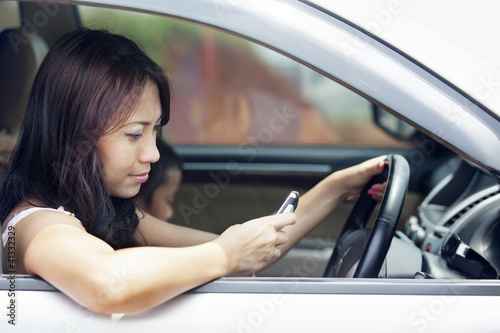 Photo: Woman using mobile phone while driving Woman using mobile phone while driving