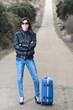 Woman in Lonely Road with Suitcase