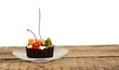 Chocolate cupcake with a cherry and tropical fruit on glass dish Chocolate cupcake with a cherry and tropical fruit on glass dish
