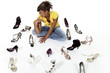 woman sitting on the ground with many shoes