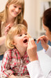 Pediatrician examine child throat look with light
