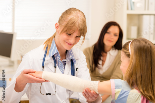 Photo: Pediatrician checking bandage girl arm Pediatrician checking bandage girl arm