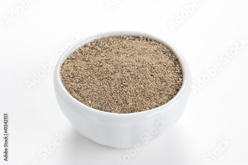 Photo: Black pepper ground (Piper nigrum) in a white bowl on white back Black pepper ground (Piper nigrum) in a white bowl on white back