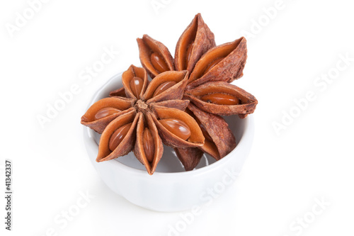 Photo: Anise star (Illicium verum) in a white bowl on white background Anise star (Illicium verum) in a white bowl on white background