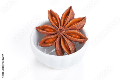 Photo: Anise star (Illicium verum) in a white bowl on white background Anise star (Illicium verum) in a white bowl on white background